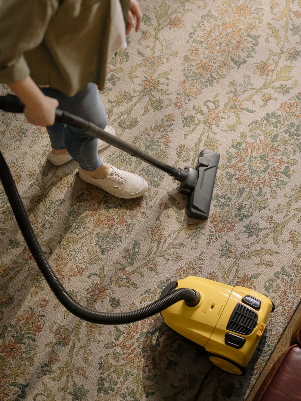 Cleaner vacuuming a rug in an Austin home
